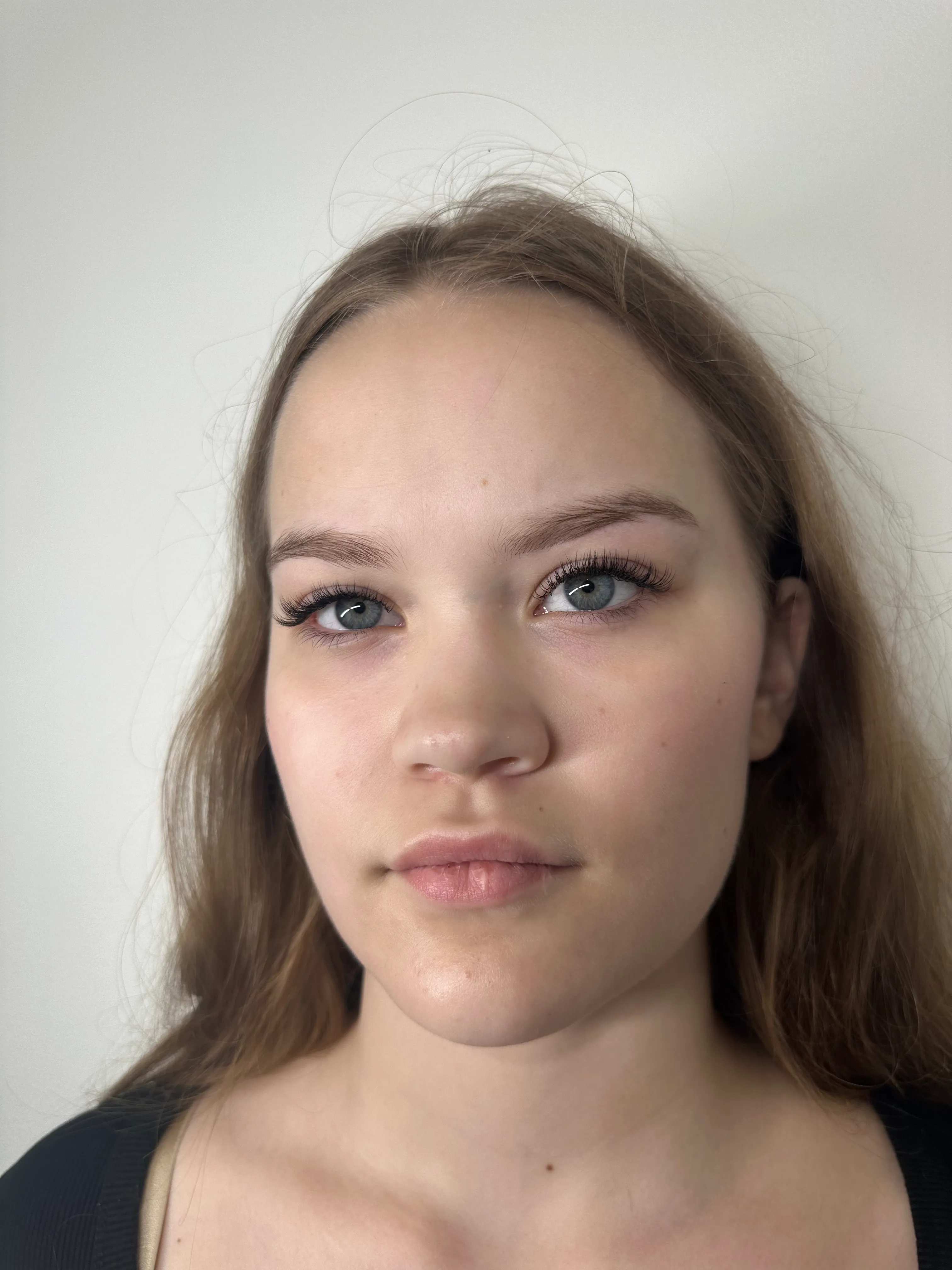 Close-up portrait with classic curled lash extensions and natural makeup.